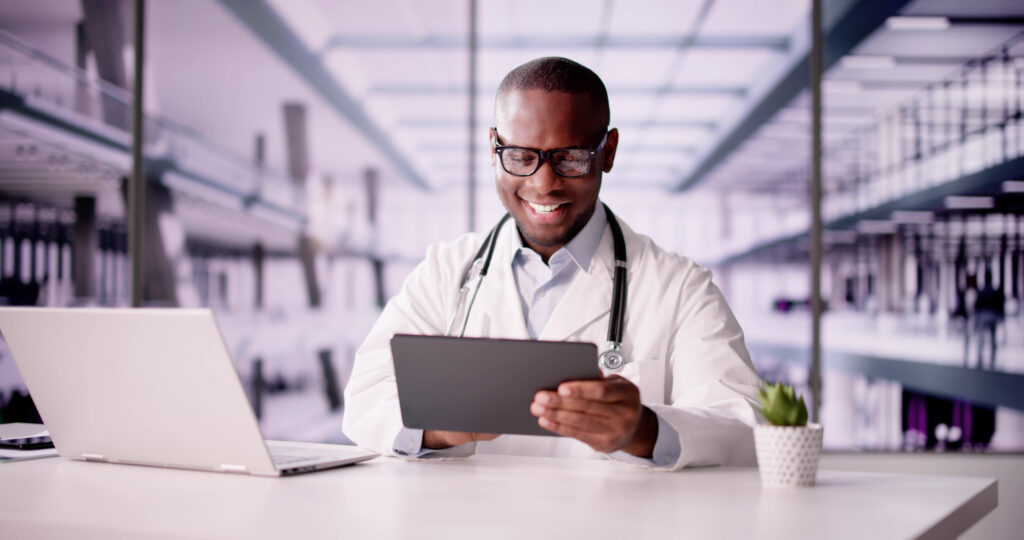 Innovative black doctor transforms healthcare through virtual consultations with patients using laptop and tablet for online services.